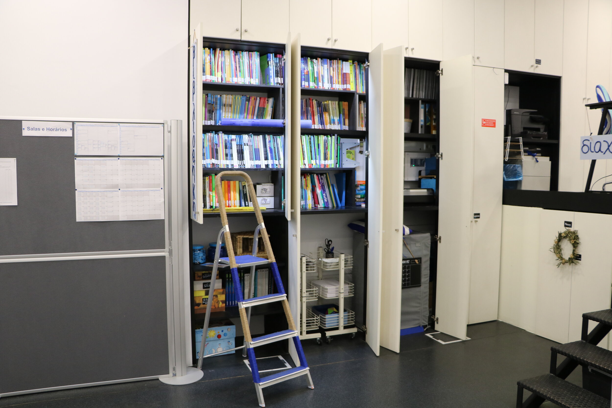 Mini biblioteca com estantes de livros e material didático